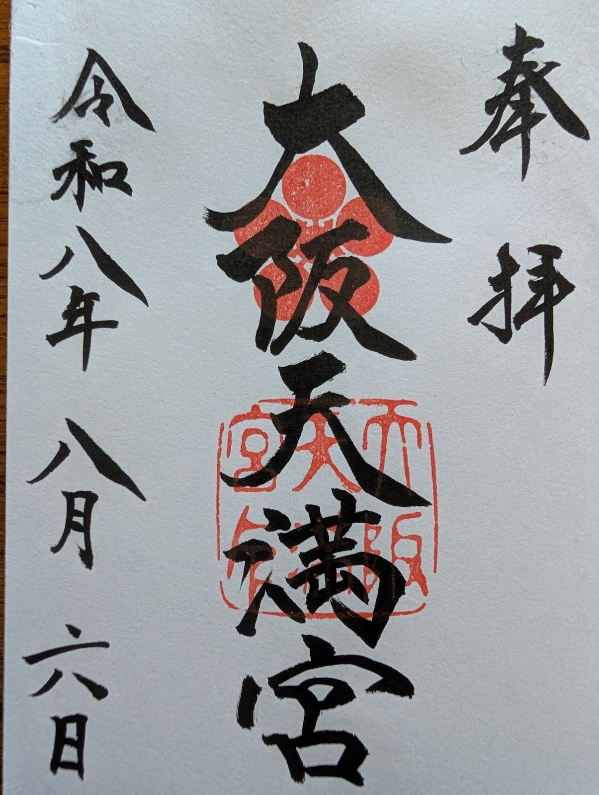 大阪天満宮の御朱印です。右に「奉拝」、中央に「大阪天満宮」と墨書きされ、朱色の梅の紋と角印が重ねて押されています。左に令和八年八月六日の日付があります。