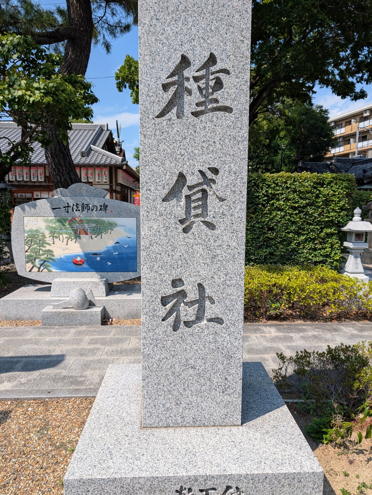 種貸社の社号標。奥に一寸法師の碑